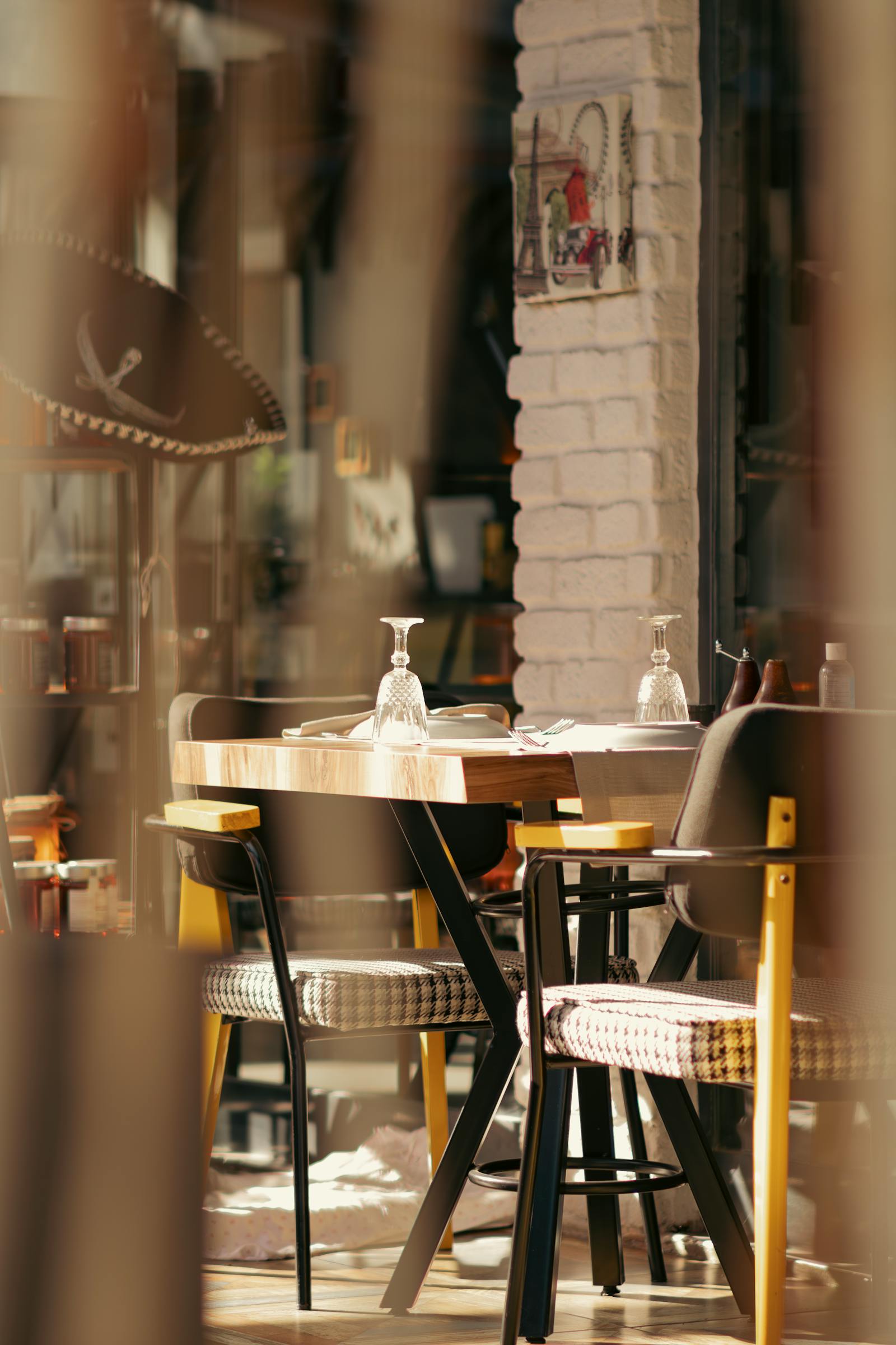 Warm restaurant interior table setting supporting hours, location, and inquiry information.