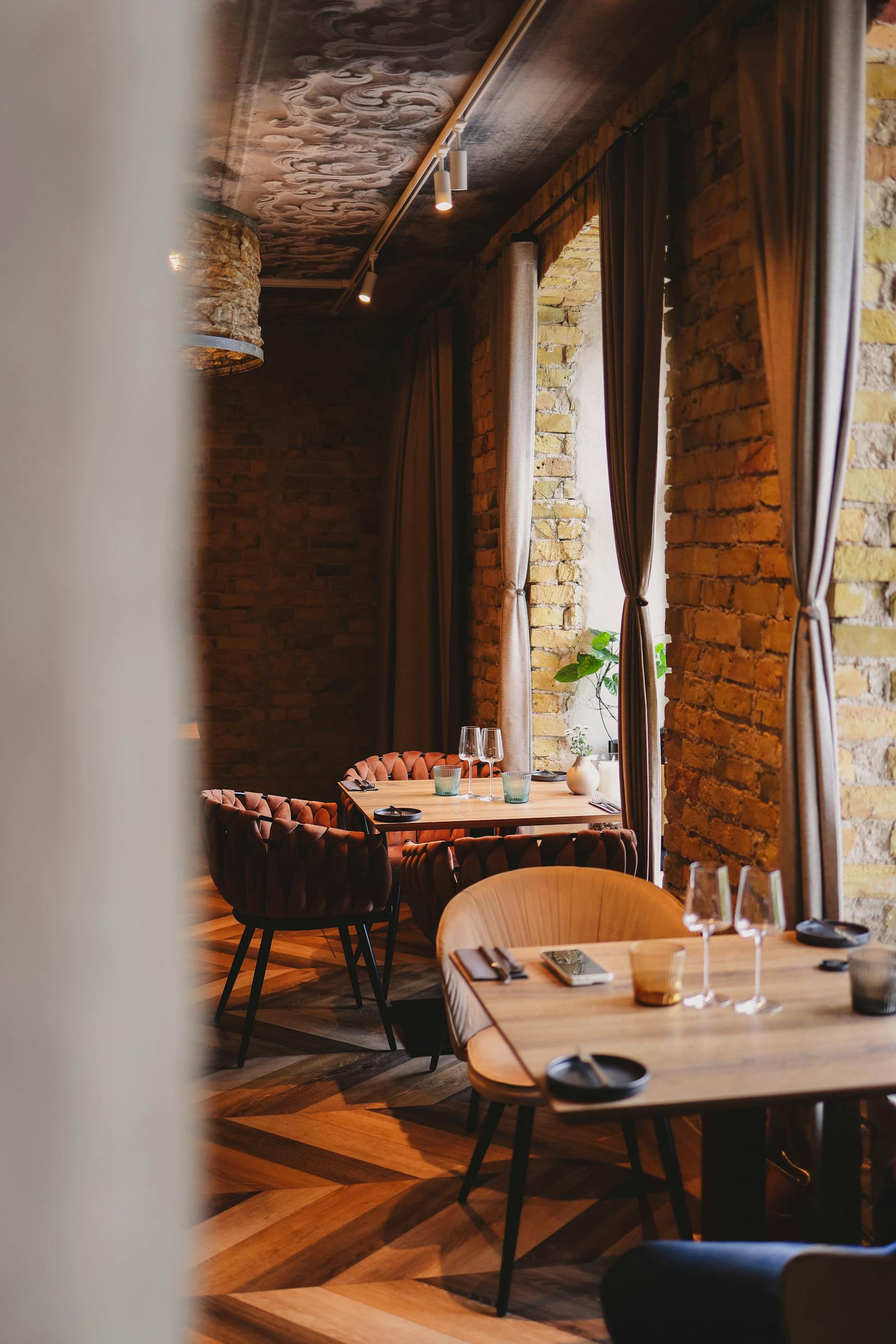 Warm restaurant dining room with set tables and soft hospitality lighting.